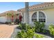 Charming front exterior showcasing arched windows, a tiled roof, and a brick driveway at 2817 La Mancha Ct, Punta Gorda, FL 33950