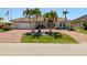 Charming home with brick driveway, palm trees, tile roof, and lush landscaping creates appealing curb appeal at 2817 La Mancha Ct, Punta Gorda, FL 33950