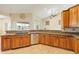 Bright kitchen with granite countertops, wood cabinets, and stainless steel dishwasher at 2817 La Mancha Ct, Punta Gorda, FL 33950