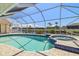 Inviting screened-in pool and spa overlooking the canal, perfect for relaxing and entertaining outdoors at 2817 La Mancha Ct, Punta Gorda, FL 33950