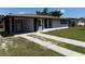 Charming single-story home featuring a well-manicured lawn, covered carport, and freshly painted exterior at 2919 Bayshore Gardens Pkwy, Bradenton, FL 34207