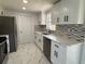 Bright kitchen boasts white cabinets, stainless appliances, and marble tile floors at 2919 Bayshore Gardens Pkwy, Bradenton, FL 34207