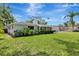 Expansive backyard features a lush lawn, mature trees, and a glass enclosed porch at 320 25Th W St, Bradenton, FL 34205