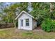 Backyard shed with a door and single window, surrounded by lawn, bushes, and trees at 320 25Th W St, Bradenton, FL 34205