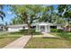 Charming one-story home features a well-manicured lawn, mature landscaping, and attached two-car garage at 320 25Th W St, Bradenton, FL 34205