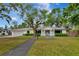 Charming home with mature trees, a well-manicured lawn, and a classic white facade at 320 25Th W St, Bradenton, FL 34205
