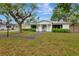 Traditional home featuring a lush front yard, mature trees, and a bright exterior at 320 25Th W St, Bradenton, FL 34205