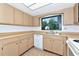 Bright kitchen featuring wood cabinets, white appliances, and a garden view, creating a functional cooking space at 320 25Th W St, Bradenton, FL 34205