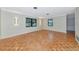 Bright living room featuring parquet flooring, a neutral color palette, and minimalist wall sconces for soft lighting at 320 25Th W St, Bradenton, FL 34205