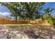 Large fenced backyard with trees, gravel landscaping, offering plenty of space for outdoor activities at 3356 Maiden Ln, Sarasota, FL 34231