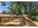 Wooden deck overlooking a serene fenced-in backyard with mature trees, perfect for outdoor entertaining at 3356 Maiden Ln, Sarasota, FL 34231