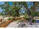 Wooden deck overlooking a fenced backyard with mature trees and a gravel area, perfect for relaxing at 3356 Maiden Ln, Sarasota, FL 34231