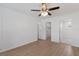 Bright bedroom with wood-look floors, ceiling fan, and multiple doors to bathroom and closet at 3356 Maiden Ln, Sarasota, FL 34231