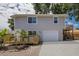 Two-story home features light gray siding, an attached garage and landscaped with palm trees at 3356 Maiden Ln, Sarasota, FL 34231