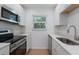 Bright kitchen with stainless appliances, quartz countertops, and natural light from the window at 3356 Maiden Ln, Sarasota, FL 34231