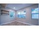 Bright bedroom featuring modern wood-look flooring, large windows, and floating shelves at 3515 W Pearl Ave, Tampa, FL 33611