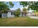 Cozy single-story home with a red door, complemented by well-maintained landscaping, offers a comfortable feel at 3515 W Pearl Ave, Tampa, FL 33611