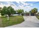 Inviting single-story home with a lush green lawn, mature trees, and a welcoming driveway, showcasing curb appeal at 3515 W Pearl Ave, Tampa, FL 33611