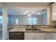 Kitchen with granite countertops looking into living room with lots of natural light at 3515 W Pearl Ave, Tampa, FL 33611