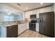 Well-lit kitchen featuring stainless steel appliances, granite countertops and wood-look tile floors at 3515 W Pearl Ave, Tampa, FL 33611