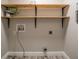 Functional laundry room with floating shelves and utility connections at 3515 W Pearl Ave, Tampa, FL 33611