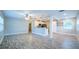 Bright, open living space featuring modern gray floors and an open-concept design flowing into the kitchen at 3515 W Pearl Ave, Tampa, FL 33611