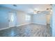 Spacious living room with gray wood-look flooring, a ceiling fan, and a bright ambiance from the front door at 3515 W Pearl Ave, Tampa, FL 33611