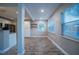 Sunlit living space with gray wood-look flooring, complemented by natural light and a view into the adjacent kitchen at 3515 W Pearl Ave, Tampa, FL 33611