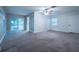 Open living room with gray carpet and sliding glass doors to the backyard at 3515 W Pearl Ave, Tampa, FL 33611