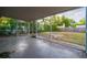 A covered patio leads to a spacious backyard that is surrounded by lush trees and a fence at 3515 W Pearl Ave, Tampa, FL 33611