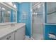 Well-lit bathroom features white vanity, and glass enclosed shower, surrounded by vibrant blue walls at 3711 118Th W St, Bradenton, FL 34210