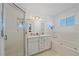 All-white bathroom with glass shower, soaking tub, dual sink vanity, and ample natural light at 3711 118Th W St, Bradenton, FL 34210