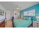 Cozy bedroom with turquoise accent wall, ceiling fan, wood floors and a view to the outside at 3711 118Th W St, Bradenton, FL 34210