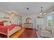 Airy bedroom with red bedding, hardwood floors, sitting chair, and nautical decor at 3711 118Th W St, Bradenton, FL 34210