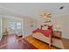 Cozy bedroom with red bedding, hardwood floors, ceiling fan, and a decorative niche at 3711 118Th W St, Bradenton, FL 34210