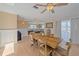 An airy dining room with wood table, seating six, and light hardwood flooring offers seamless transition into the living area at 3711 118Th W St, Bradenton, FL 34210