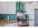 Modern kitchen with stainless steel appliances, including range hood, and granite countertops at 3711 118Th W St, Bradenton, FL 34210