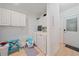 Functional laundry room with white cabinetry, washer, dryer, and exterior access at 3711 118Th W St, Bradenton, FL 34210