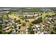 Aerial view of a community, highlighting a home with a sparkling pool, situated on a golf course with a pond at 3859 Little Country Rd, Parrish, FL 34219