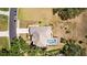 Aerial view of backyard with a screened pool, lush lawn, and a variety of mature trees and landscaping at 3859 Little Country Rd, Parrish, FL 34219