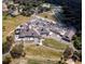 Aerial view highlighting the community clubhouse, tennis courts, and extensive parking at 3859 Little Country Rd, Parrish, FL 34219