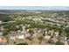 Aerial view of neighborhood homes nestled amongst trees and lush landscaping with a golf course in the background at 3859 Little Country Rd, Parrish, FL 34219