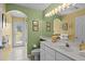 Well-lit bathroom with white vanity, tile floor, and access to the lanai at 3859 Little Country Rd, Parrish, FL 34219