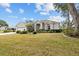 Well-manicured front yard with lush lawn, trimmed bushes, and a welcoming facade at 3859 Little Country Rd, Parrish, FL 34219
