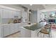 Bright kitchen featuring white cabinetry, tile floors, and breakfast bar with chairs at 3859 Little Country Rd, Parrish, FL 34219