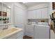 Functional laundry room with sink, overhead cabinets, washer and dryer at 3859 Little Country Rd, Parrish, FL 34219