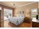 Cozy main bedroom with wood floors, natural light, ceiling fan, and private patio access at 3859 Little Country Rd, Parrish, FL 34219
