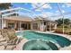 Covered pool and spa with clear water, patio, and access to the home through sliding glass doors at 3859 Little Country Rd, Parrish, FL 34219