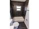 Modern bathroom with black marble-style tiled walls, shower-over-tub, and a contrasting white toilet and fixtures at 4501 20Th S Ave, St Petersburg, FL 33711