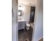 Bathroom with a marble-style tiled shower, gray vanity, and black fixtures seen through a doorway, offering a modern touch at 4501 20Th S Ave, St Petersburg, FL 33711